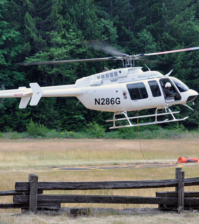 bell 407 helicopter landing in a field